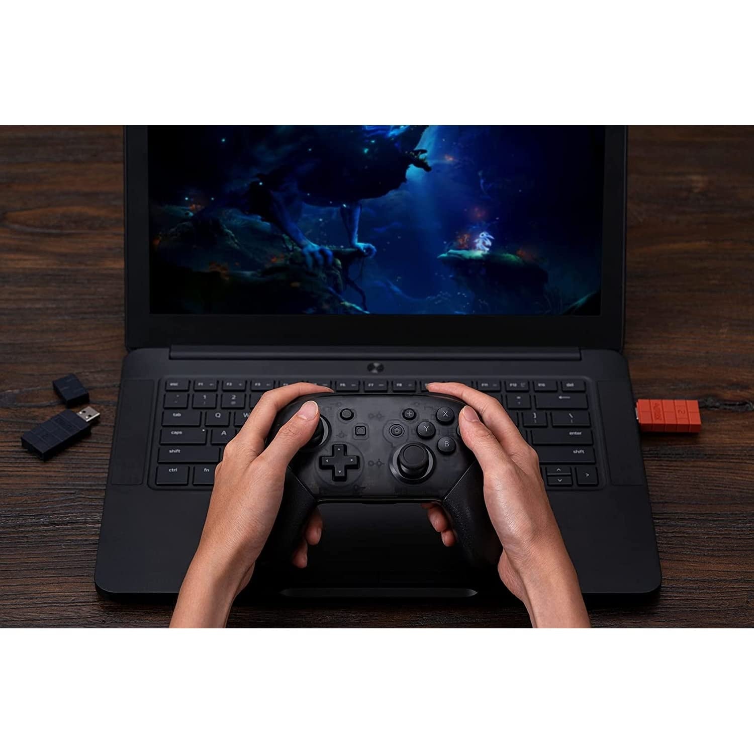 User playing a PC game wirelessly with a controller connected through the 8Bitdo Wireless Bluetooth Adapter 2 plugged into a laptop.