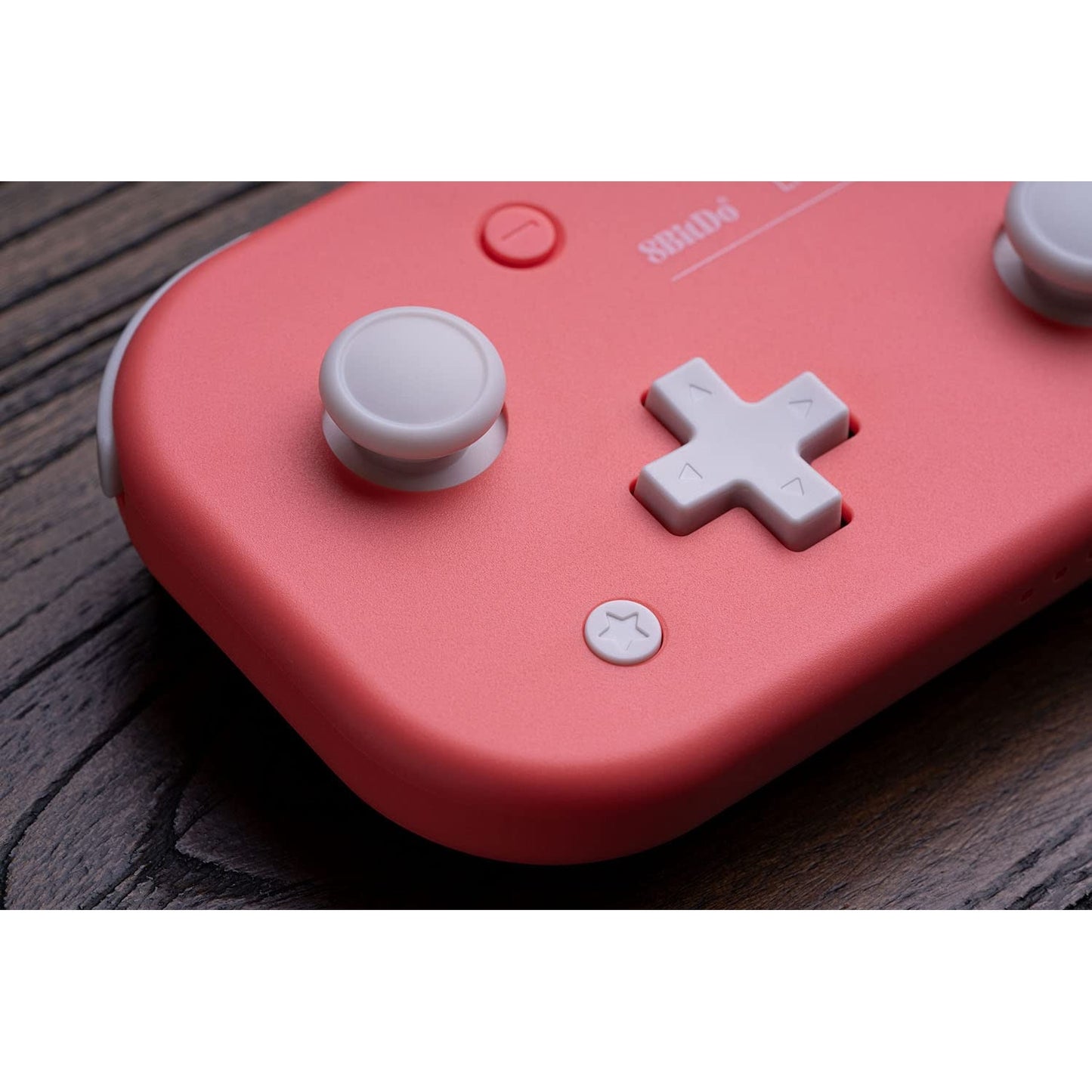 Macro close-up of 8BitDo Lite 2 pink controller showing joystick and D-pad detail.