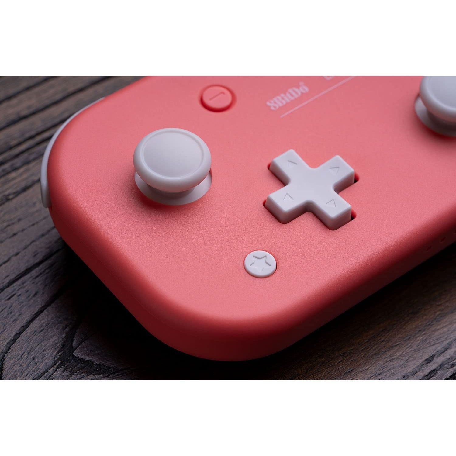 Macro close-up of 8BitDo Lite 2 pink controller showing joystick and D-pad detail.