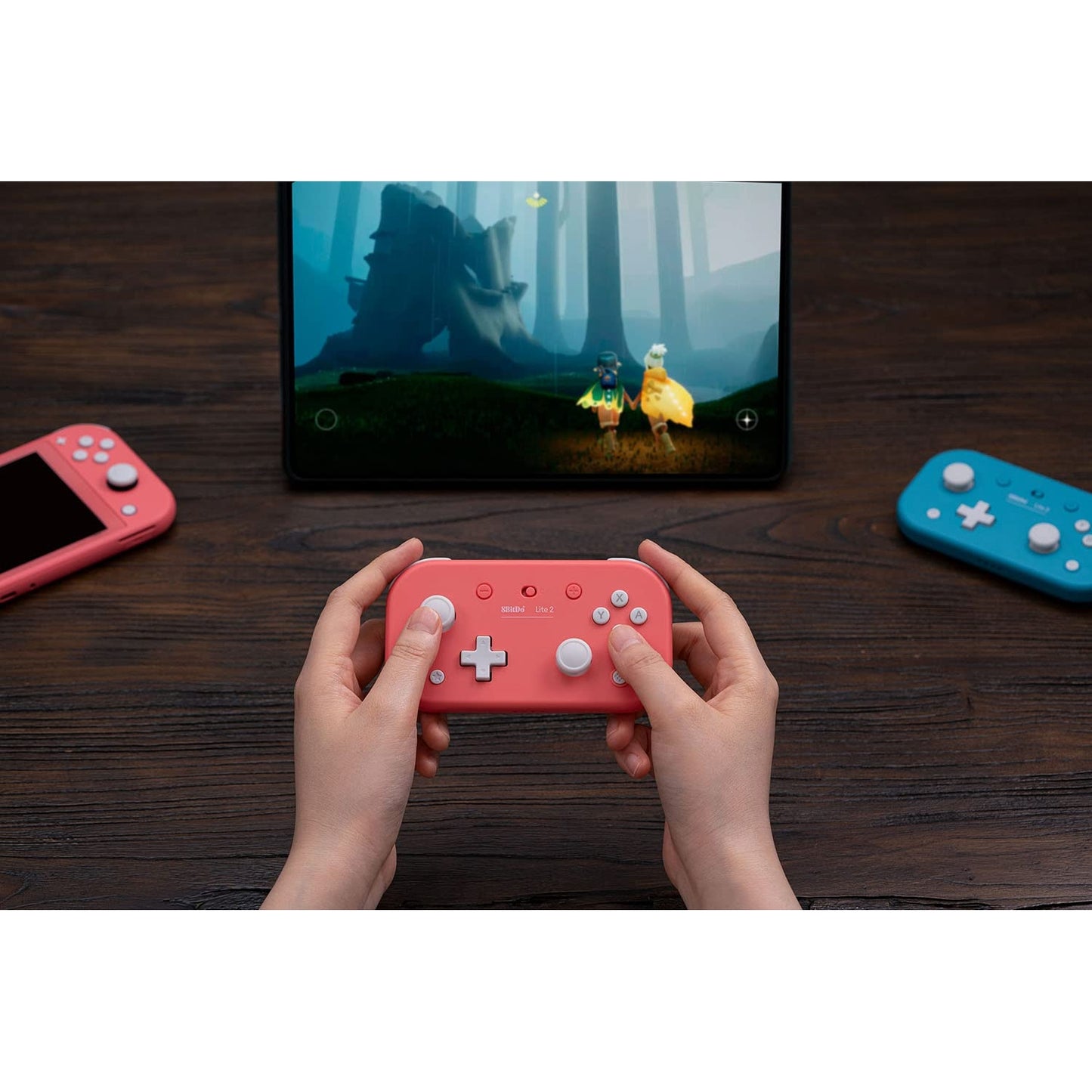User playing a game on a tablet with the 8BitDo Lite 2 pink Bluetooth controller.
