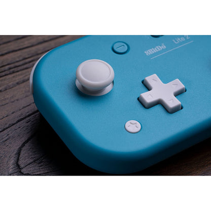 Macro close-up of 8BitDo Lite 2 joystick and D-pad in turquoise finish.