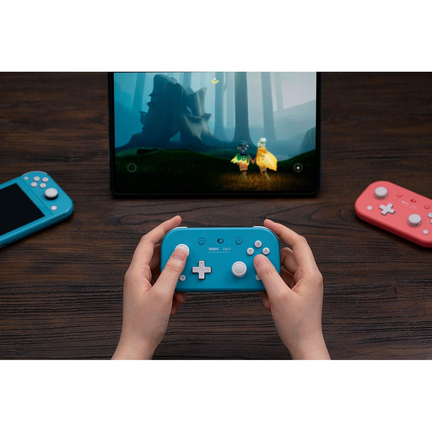 User playing on a tablet using the 8BitDo Lite 2 Bluetooth gamepad in turquoise.