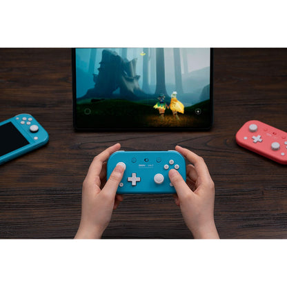 User playing on a tablet using the 8BitDo Lite 2 Bluetooth gamepad in turquoise.
